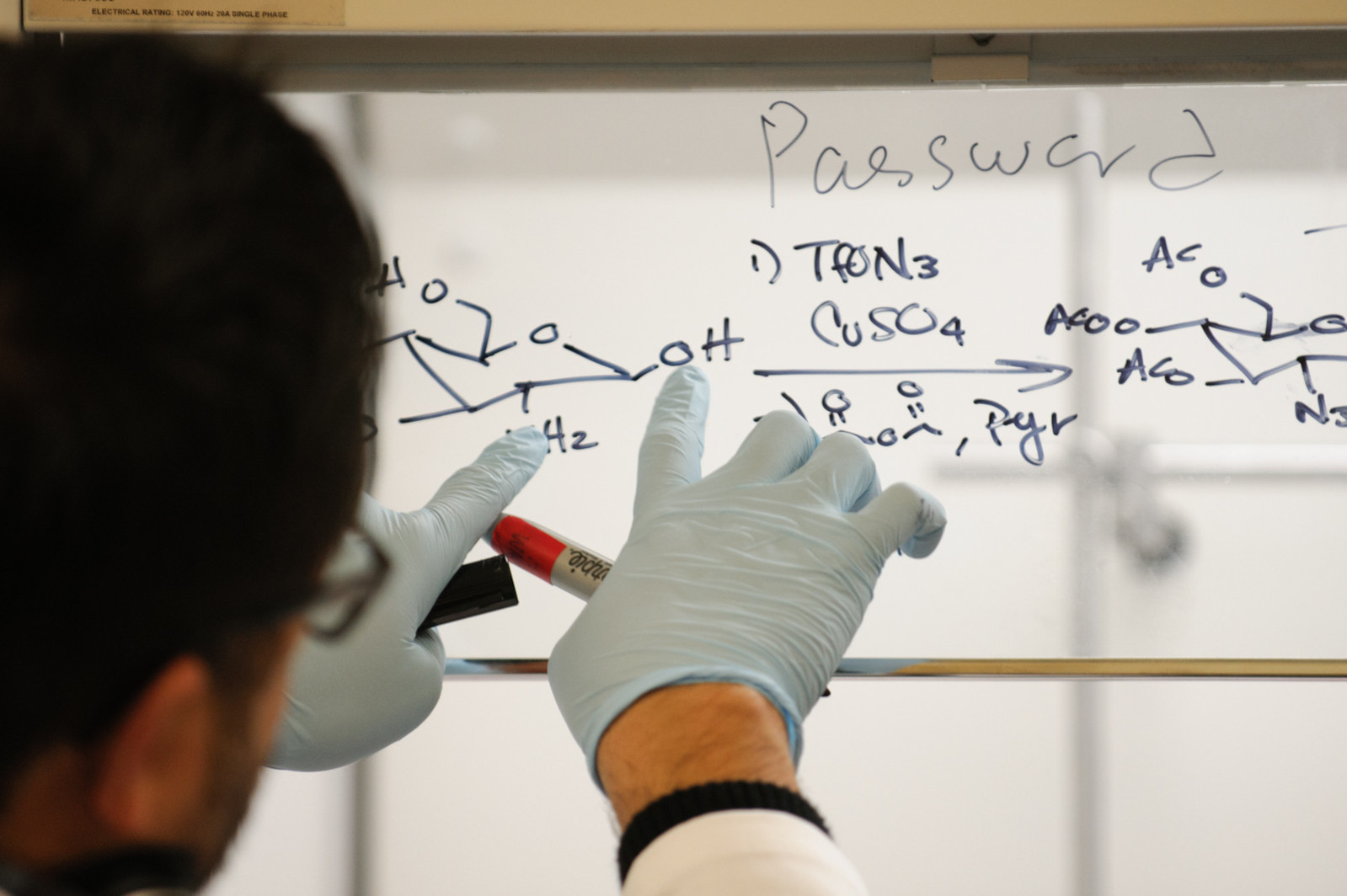 A student writes a formula on whiteboard