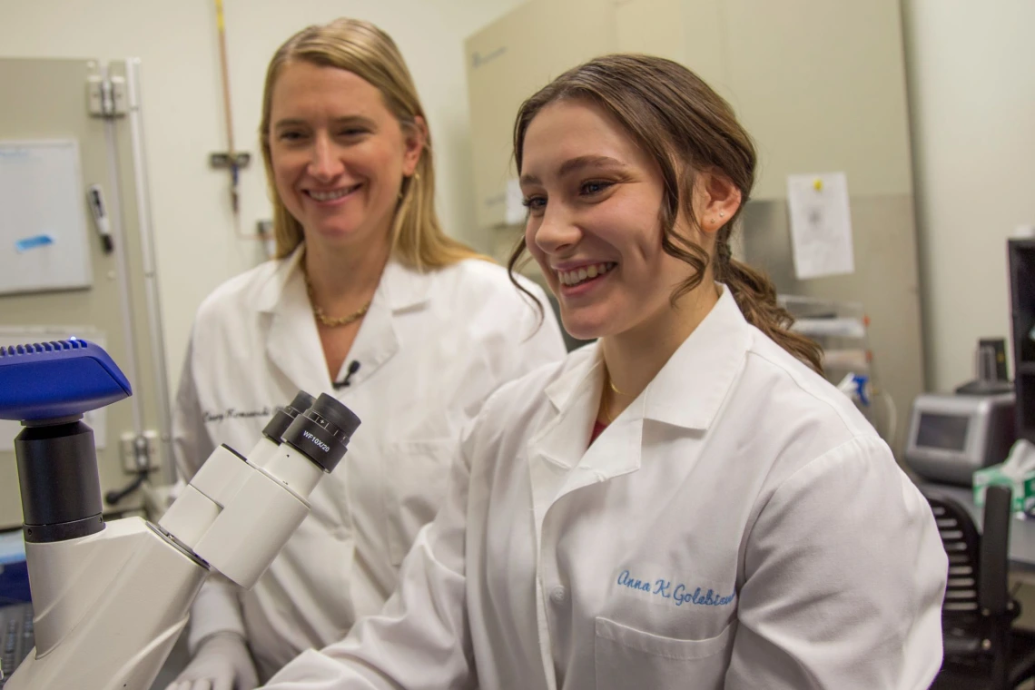  Anna Golebiewski pictured in a lab in front of a microscope