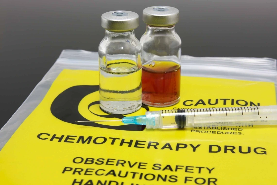 Image of syringe, two vials and a yellow chemotherapy waste bag